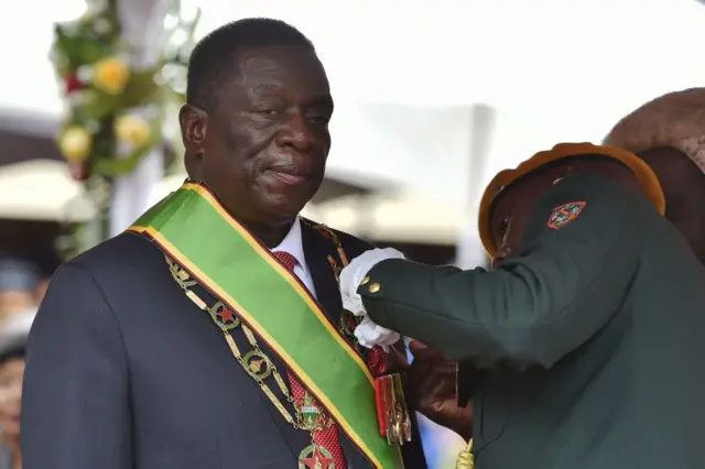 Zimbabwean new interim President Emmerson Mnangagwa receives the chain and sash of office from the Chief judge of the Supreme Court, Chief Justice Luke Malaba as he is officially sworn-in during a ceremony in Harare on November 24, 2017.