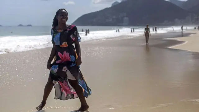 A young lady poses by the beach