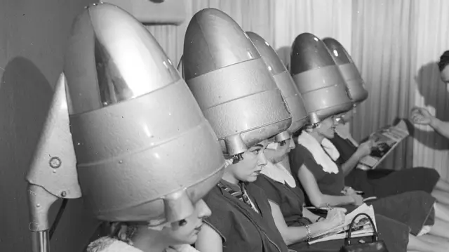 Women having hair blow dried in 1955