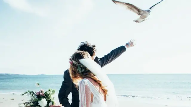 The couple being swooped on by a seagull