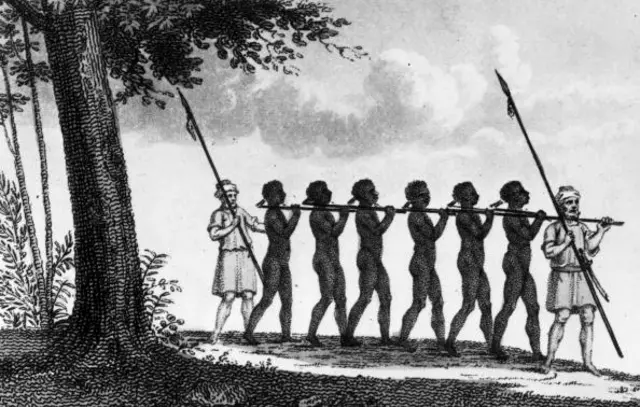 1821: A chain of slaves, flanked by men with spears, being taken from the African interior.