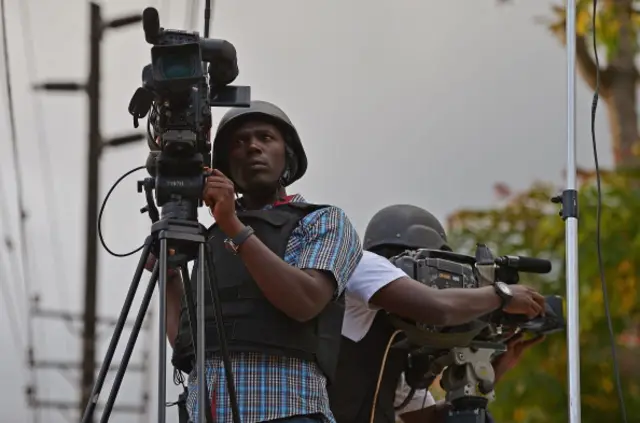 Kenyan media wearing bullet proof jackets and helmets film near Westgate mall in Nairobi on September 22, 2013.