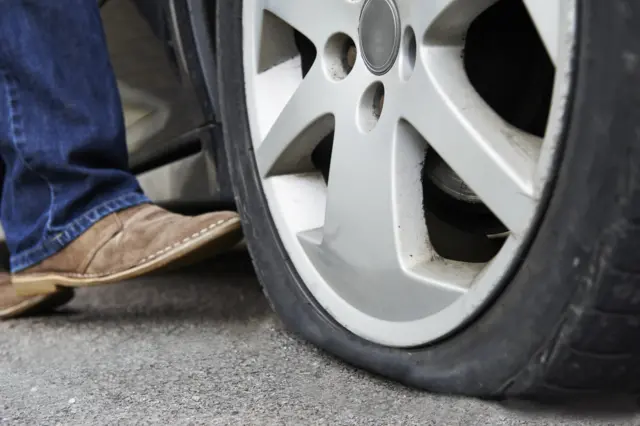 A man kicking a tyre