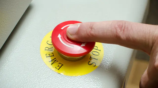 An finger on an emergency stop button