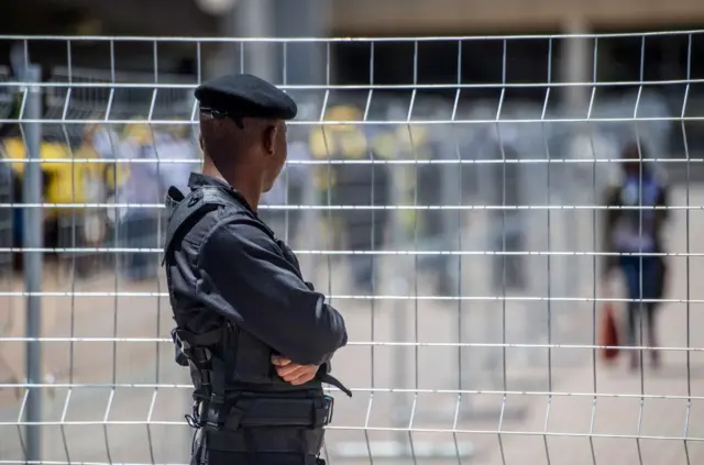 A policeman looks through a fence on December 16, 2017