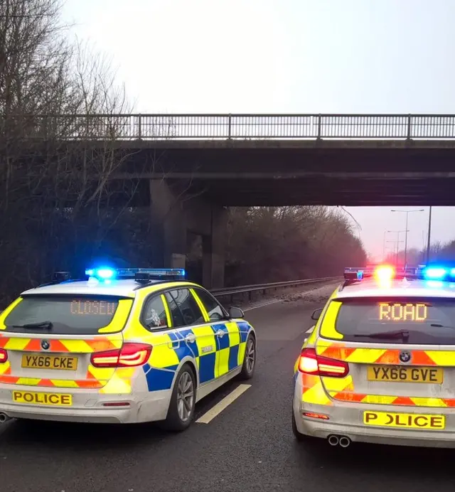 Police cars stopping traffic by bridge