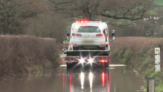 Car being towed away from water