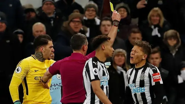 Dwight Gayle is booked by the referee