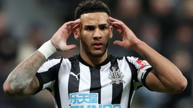 Jamaal Lascelles looks dejected after Man City score