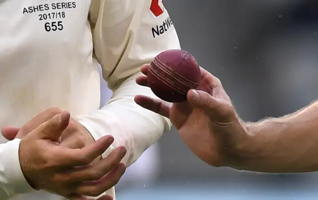 Chris Woakes hands Joe Root the ball