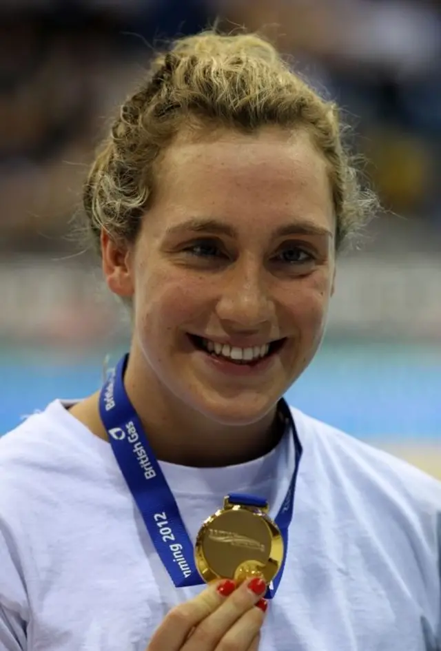 Lizzie Simmonds holding a gold medal.