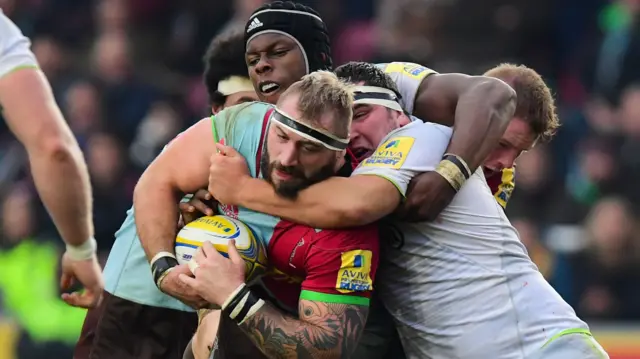 Joe Marler is tackled by Maro Itoje and Jamie George