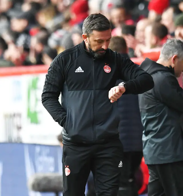 Derek McInnes consults his watch as the clock ticks down