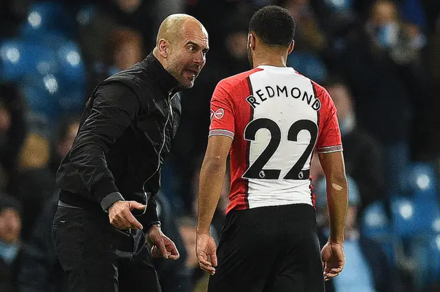 Pep Guardiola speaks to Nathan Redmond