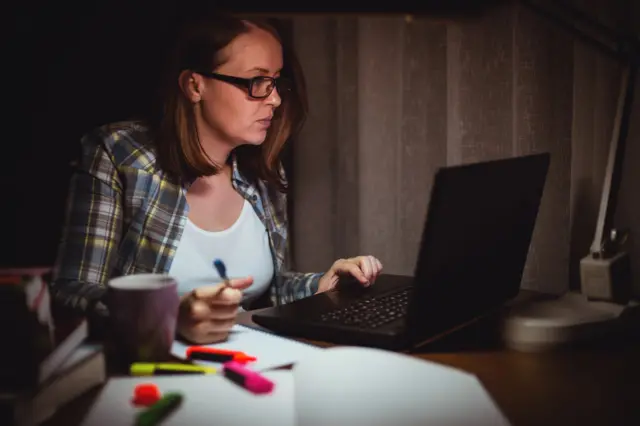 A woman working at home at night