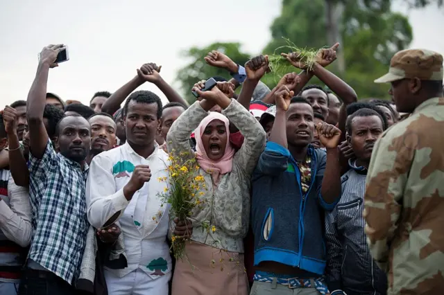 Residents of Bishoftu crossed their wrists above their heads as a symbol for the Oromo anti-government protesting movement during the Oromo new year holiday Irreechaa in Bishoftu on October 2, 2016. Several people were killed in a stampede near the Ethiopian capital on October 2 after police fired tear gas at protesters during a religious festival, according to an AFP photographer at the scene.