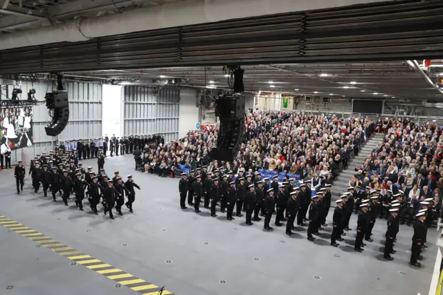 HMS Queen Elizabeth's ships company march on to parade at the commissioning of HMS Queen Elizabeth