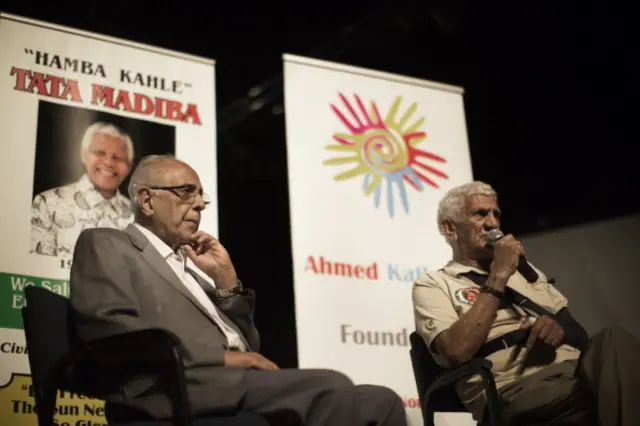 Anti-apartheid activist and close friend of former South African President Nelson Mandela, Ahmed Kathrada (L), talks next to Nelson Mandela's fellow Robben Island prisoner, Laloo 'Isu' Chiba, during a tribute to Mandela at Gandhi Hall on December 8, 2013 in Johannesburg.