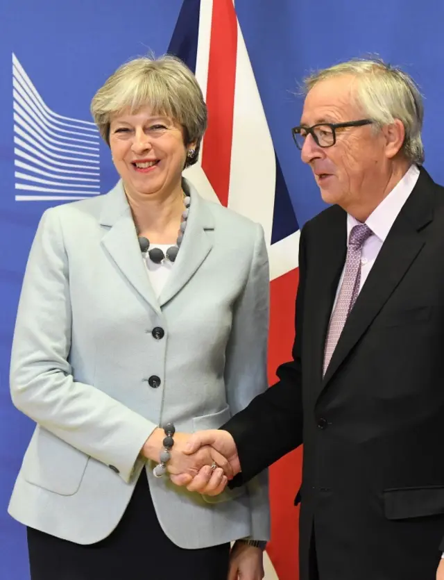 Theresa May and Jean-Claude Juncker shake hands