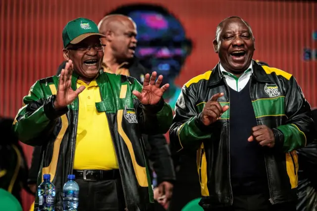 South African President Jacob Zuma (L) and Deputy President Cyril Ramaphosa (R) sing and dance during the closing session of the South African ruling party African National Congress policy conference in Johannesburg on July 5, 2017.