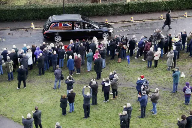 Crowds applaud the funeral cortege of Graham Taylor