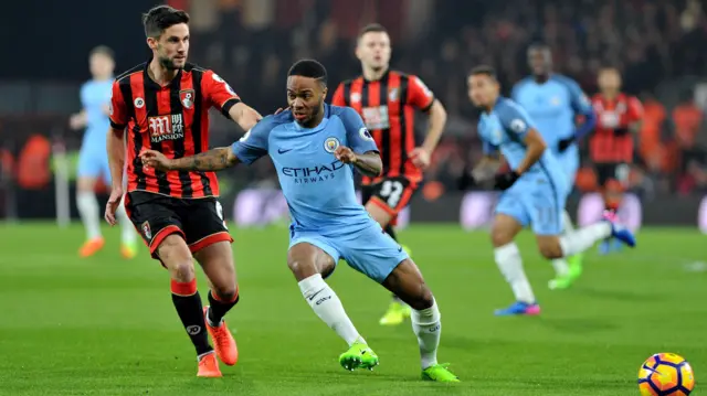 Raheem Sterling, of Manchester City, on the ball as Andrew Surman, of Bournemouth, looks on