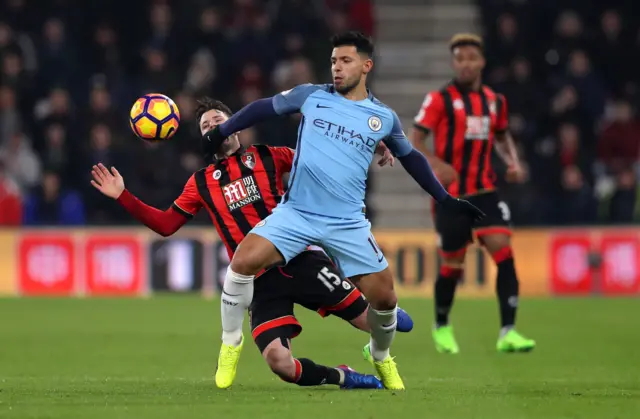 Manchester City"s Sergio Aguero is challenged by AFC Bournemouth"s Adam Smith