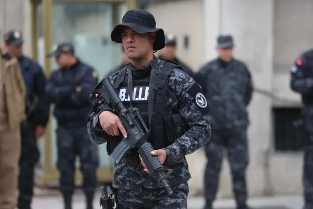 Police officers stand guard in front of the Ministry of the Interior