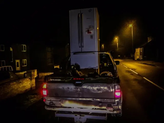 Fridge loaded on the back of a vehicle