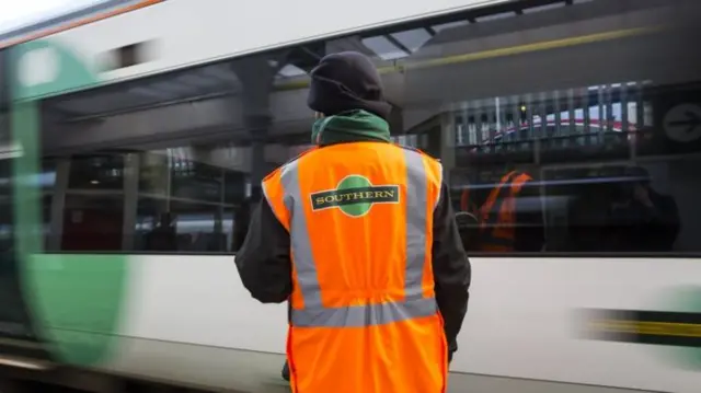 A Southern rail worker in front of a train