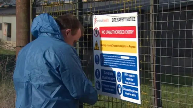 Notice on fence at bird flu farm warning of no unauthorised entry