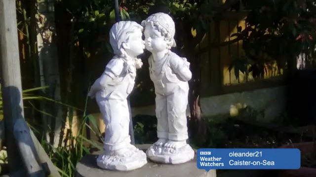 A garden status showing a kissnig couple