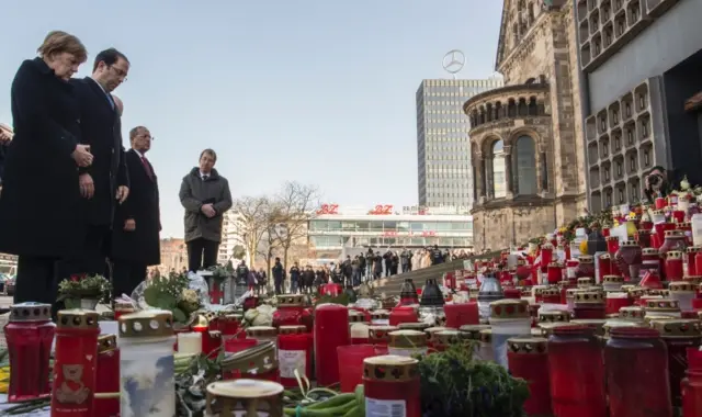 German Chancellor Angela Merkel (L) and Tunisian Prime Minister Youssef Chahed (2nd L) lay down flowers at the site of the Berlin Christmas Market attack, on February 14, 2017