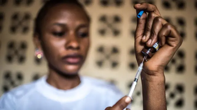 Nurse fills syringe with yellow fever vaccine