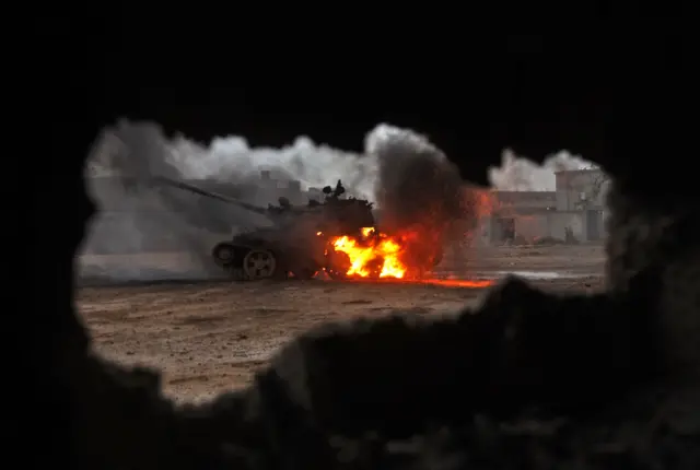 A tank is seen on fire during clashes between soldiers from the Libyan National Army, and jihadist fighters.