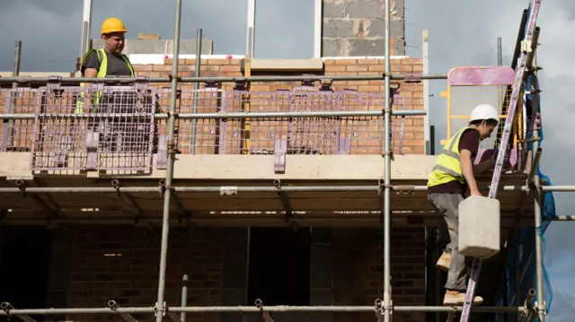 Builders constructing a house