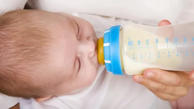 Baby with milk in bottle