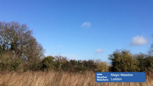 Blue sky, with a few clouds, over countryside