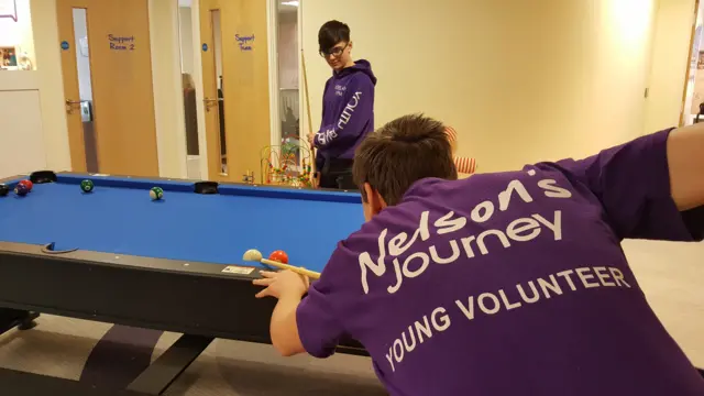 Keelan and Aaron in purple Nelson's Journey clothes, playing pool