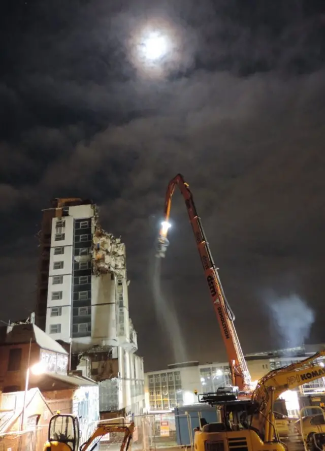 Crane lights and diggers at demolition site