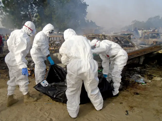 Forensics cover a dead body and clear the scene of a blast in Maiduguri on February 17, 2017.
