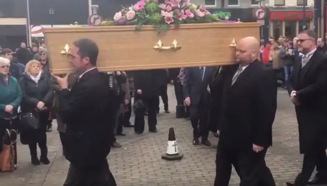 Coffin being carried into church