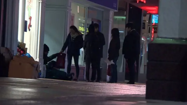 Students handing out food and water to homeless people