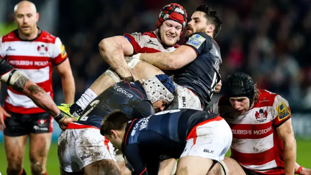 Sean Maitland of Saracens is challenged by Tom Savage of Gloucester Rugby