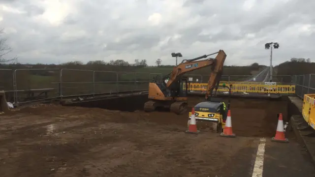 Diggers excavate on a road bridge over the River Ise on the A6.