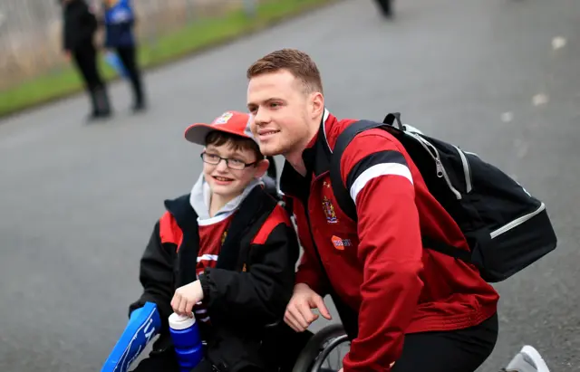 Joe Burgess poses for a photograph with a young Wigan fan