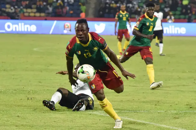 Christian Bassogog advances with the ball past Ghana"s midfielder Frank Acheampong to score his team"s second goal