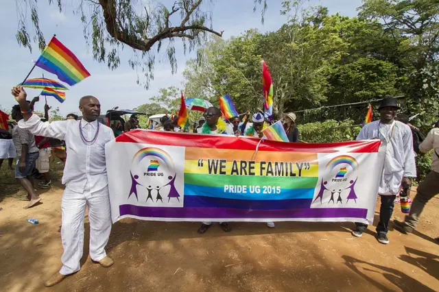 Ugandans hold up a banner at a gay rally