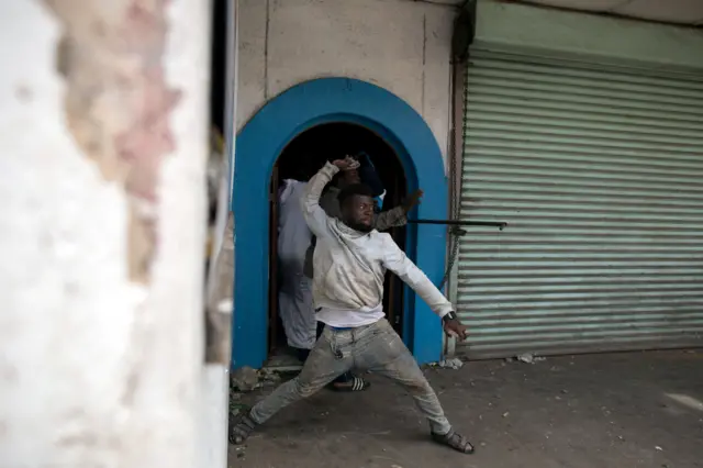 Nigerian migrants throw stones at an angry mob outside a church in Pretoria, South Africa February 18, 2017.