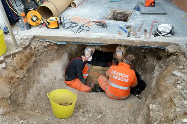 Police uncovering cesspit in garage